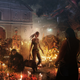 Lara Croft stands amidst many candles, while others around her appear to be mourning.